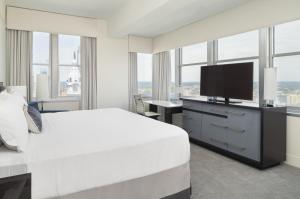 um quarto de hotel com uma cama e uma televisão de ecrã plano em Loews Philadelphia Hotel em Filadélfia