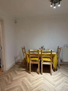 mesa de comedor y sillas con mantel amarillo en Gracehill Suite, en Londres