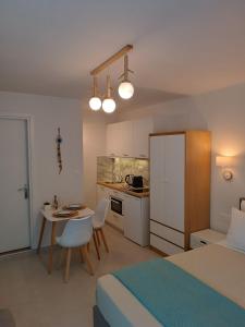 a bedroom with a bed and a table and a kitchen at ALMIRA Studios Limnos 2 in Mirina