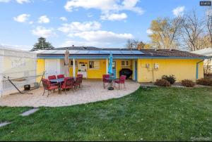 ein gelbes Haus mit einem Tisch und Stühlen im Hof in der Unterkunft Sunny Beach House of Olde Town Arvada in Arvada