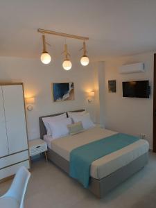 a bedroom with a large bed with lights on it at ALMIRA Studios Limnos 2 in Mirina