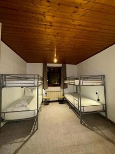 two bunk beds in a room with a wooden ceiling at Wohnung Zur Post in Bruck an der Großglocknerstraße