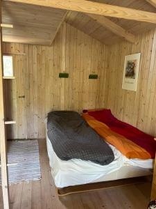 a bedroom with a bed in a wooden room at Charmerende skovhytte in Ringkøbing