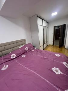 Una cama con una manta morada encima. en Downtown Apartment, en Strumica