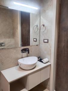 W łazience znajduje się biała umywalka i lustro. w obiekcie Buddha Stays w mieście Waranasi