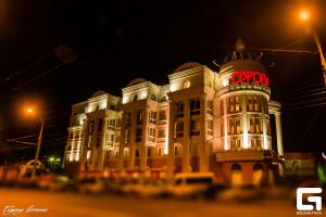 un bâtiment avec un panneau de néon sur lui la nuit dans l'établissement Europa Hotel, à Irkoutsk