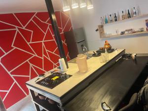 a long counter in a room with a red wall at Loft IA79 in San Baltasar