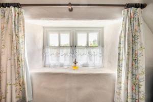 una ventana con cortinas y un jarrón en el alféizar de la ventana en Rosehill House en Dungannon