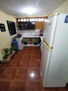 a kitchen with a white refrigerator and a wooden floor at Casa para 12 personas Acceso a la represa y Barbacoa in Guatapé +17 photos