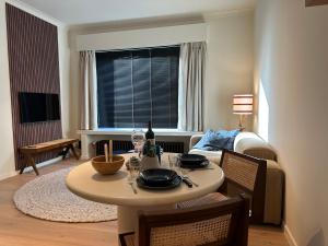 sala de estar con mesa y sofá en Home away from home by the beach, en Ostende