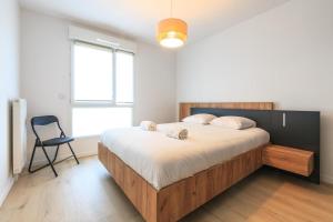 1 dormitorio con 1 cama grande y 1 silla en Rohan - T3 - parking - calme - wifi, en Vannes