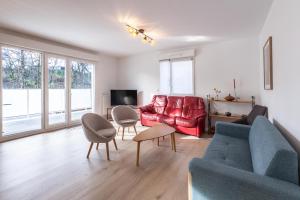 sala de estar con sofá rojo y sillas en Rohan - T3 - parking - calme - wifi, en Vannes