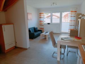 sala de estar con mesa y sofá en Apartments, en Papenburg