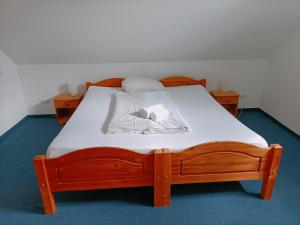 パーペンブルクにあるApartmentsの木製ベッド(白いシーツとテディベア付) +2枚の写真