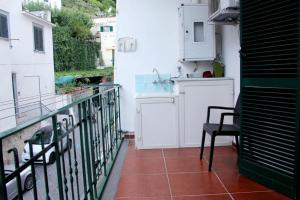 einen Balkon mit einem Tisch, einem Stuhl und einem Waschbecken in der Unterkunft Casa Rosa Atrani in Atrani