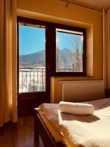 a bedroom with a bed and two windows with a view at Bacówka Na Bundówkach in Zakopane