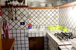 a kitchen with a sink and a stove top oven at Casa Rosa Atrani in Atrani