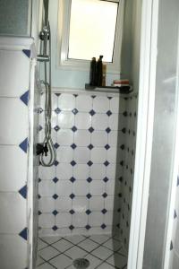 a bathroom with a shower with blue and white tiles at Casa Rosa Atrani in Atrani +3 photos