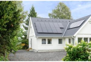 une maison avec des panneaux solaires sur le toit dans l'établissement Three Bedroom Villa Segersjö, à Tumba