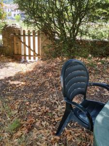 une chaise noire assise dans l'herbe près d'une clôture dans l'établissement Rendez-vous sous le tilleul, en Cevennes., à Molières-Cavaillac