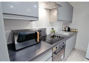 eine Küche mit einer schwarzen Mikrowelle auf der Theke in der Unterkunft Charming 1BR flat in Maidstone in Maidstone