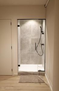La salle de bains est pourvue d'une douche et d'une paroi en verre. dans l'établissement PRET A GOUTER bistro bar bed, à Heusden-Zolder