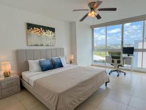 um quarto com uma cama, uma secretária e uma ventoinha de tecto em Alojamiento con vistas Costa del Este 1 na Cidade do Panamá