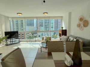 uma sala de estar com um sofá e uma televisão em Alojamiento con vistas Costa del Este 1 na Cidade do Panamá