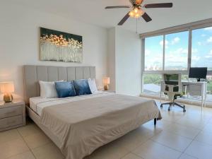 um quarto com uma cama, uma secretária e uma ventoinha de tecto em Alojamiento con vistas Costa del Este 1 na Cidade do Panamá