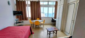 Schlafzimmer mit einem Bett, einem Tisch und Stühlen in der Unterkunft Apto vista Privilegiada da Praia in São Vicente