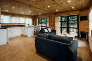 a living room with two couches and a kitchen at Woodlakes Country Park in King's Lynn +142 photos