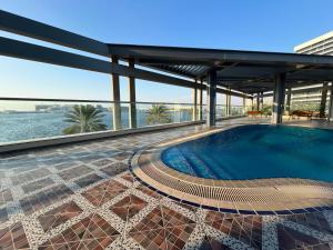 een zwembad op de top van een gebouw bij Nearest to the Airport l Beautiful 1 BR Apt in Abu Dhabi