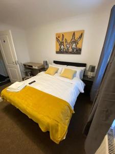 ein Schlafzimmer mit einem großen Bett und einer gelben Decke in der Unterkunft Huge 6 Bed house & 6 Bathrooms. in Boston