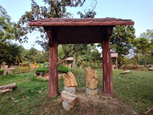 a small wooden structure in a field of grass at Muktomon Hotel & Resort in Bolpur