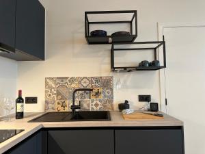 a kitchen with a sink and a bottle of wine at Home away from home by the beach in Ostend