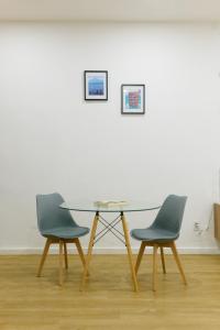 two chairs and a table in front of a white wall at Casa Valencia 1 in Santa Elena