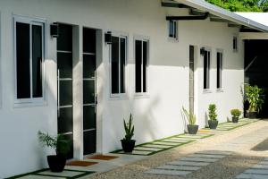 a white building with black windows and potted plants at Casa Valencia 1 in Santa Elena