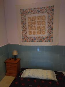 Habitación hippie في كارتاهينا: غرفة نوم مع لحاف معلق فوق سرير