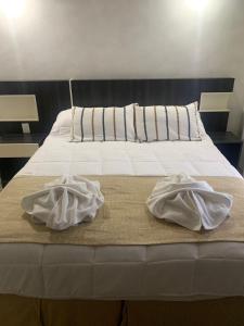 Una cama con dos toallas encima. en Glo apart hotel en Cañuelas