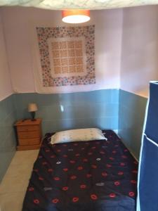 a small bedroom with a bed with a black comforter at Habitación hippie in Cartagena