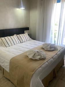 1 cama grande con 2 almohadas encima en Glo apart hotel en Cañuelas