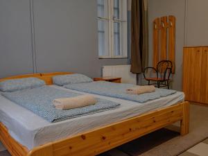 ein Schlafzimmer mit einem Holzbett mit Handtüchern darauf in der Unterkunft DeeP Guest House in Budapest