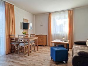 ein Wohnzimmer mit einem Tisch, Stühlen und einem Sofa in der Unterkunft HoFer am Zeitberg Ferienwohnung Lindenbach in Bad Kohlgrub