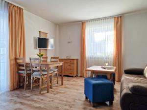 a living room with a table and chairs and a couch at HoFer am Zeitberg Ferienwohnung Lindenbach in Bad Kohlgrub