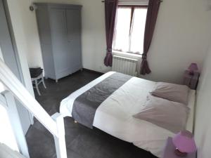 a bedroom with a bed and a window at gîte composé de 2 maisons avec cheminée et sauna in Houdetot