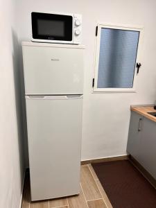 a microwave on top of a refrigerator in a kitchen at Apartamento en Los cristianos 2 habitaciones 4 huespedes Vv Elenita in Los Cristianos