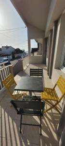 un patio avec deux chaises et une table sur un balcon dans l'établissement T3 “Belle-île“- 50 m de la plage de Fort Bloqué/Ploemeur, à Ploemeur