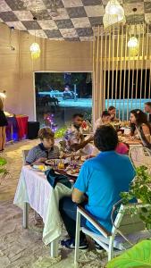 un grupo de personas sentadas en una mesa comiendo en Alimas Holiday Retreat Maldives en Felidhoo