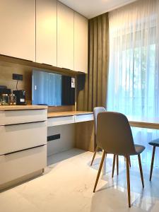 uma cozinha com uma secretária, uma cadeira e uma janela em Green Side Studio em Michalovce