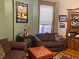 a living room with a couch and a chair at Queen Bed with Shared Bathroom in Lakeview - 2b in Chicago